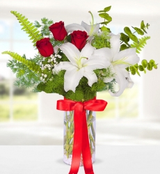 Lilyum Kırmızı Gül Zarif cam vazo içerisinde beyaz lilyum, kırmızı gül, cipsofilya ve yeşillikler ile hazırlanmıştır.
