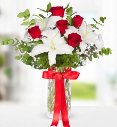 Kırmızı Gül ve Beyaz Lilyum Silindir cam vazo içerisinde kırmızı gül, beyaz lilyum ve yeşilliklerle hazırlanmıştır